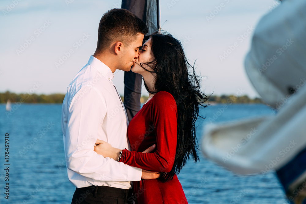 Young beautiful married couple embracing on the yacht on vacation