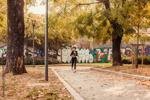 Fototapeta Naklejka Na Ścianę i Meble -  Jogger portrait running in urban autumnal park