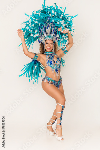 Gorgeous and cheerful brazilian samba dancer wearing traditional costume and performing photo