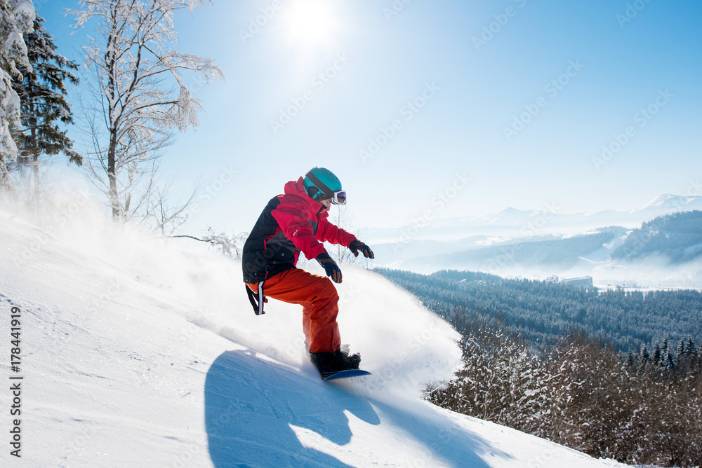 Shot of a male snowboarder enjoying riding in mountains in the morning on a sunny winter day copyspace freeride