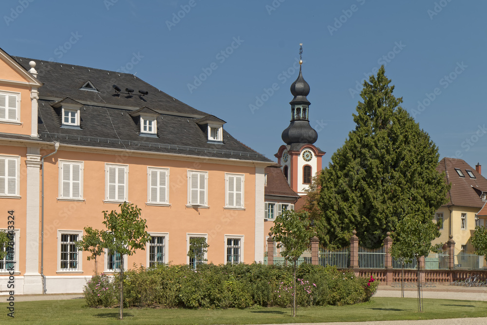 Schwetzingen, Germany - a palace courtyard with a church tower in the background Schwetzingen, Germany - a palace courtyard with a church tower in the background