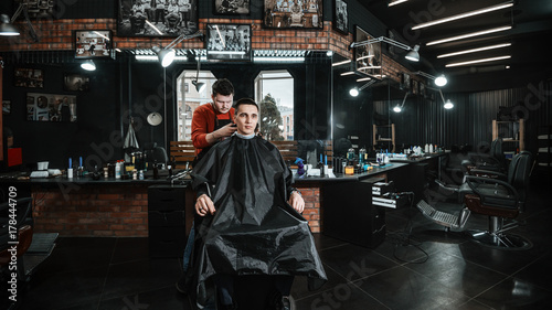 customer and barber/ Barber cutting in barbershop. Interior of hairdressing room