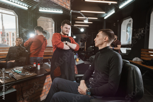 haircut is ready/ Barber evaluates the customer's haircut in the armchair