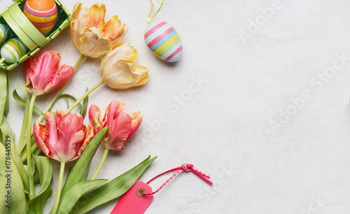 Easter background with fresh tulips, decor eggs and tag, top view, place for text