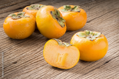 fresh persimmon fruit and section on old wood ( Diospyros virginiana L., EBENACEAE) © reshoot