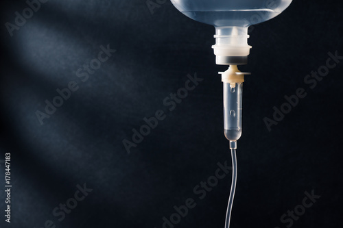 Fotografi Close up of saline solution dripping for patient against dark background