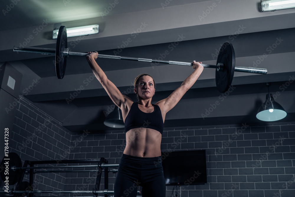 Athletic woman lifting a weight training at the gym. CrossFit