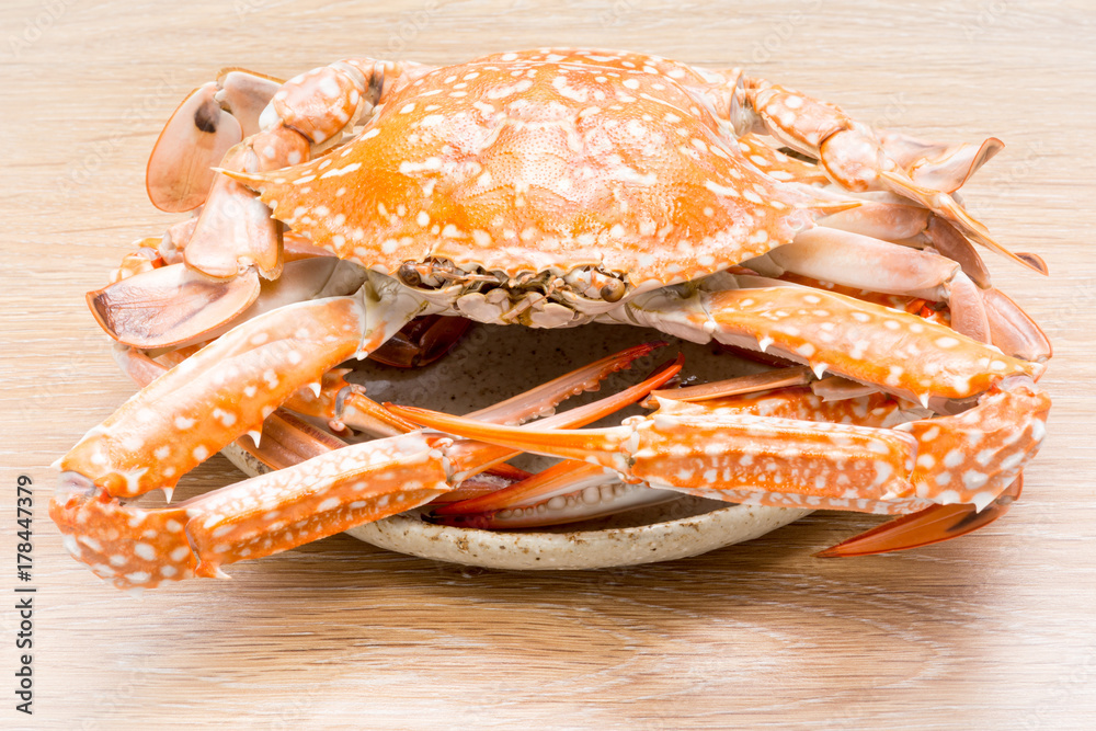 steamed horse crab or blue crab in dish on wood table background (Portunus pelagicus) steamed horse crab or blue crab in dish on wood table background (Portunus pelagicus)