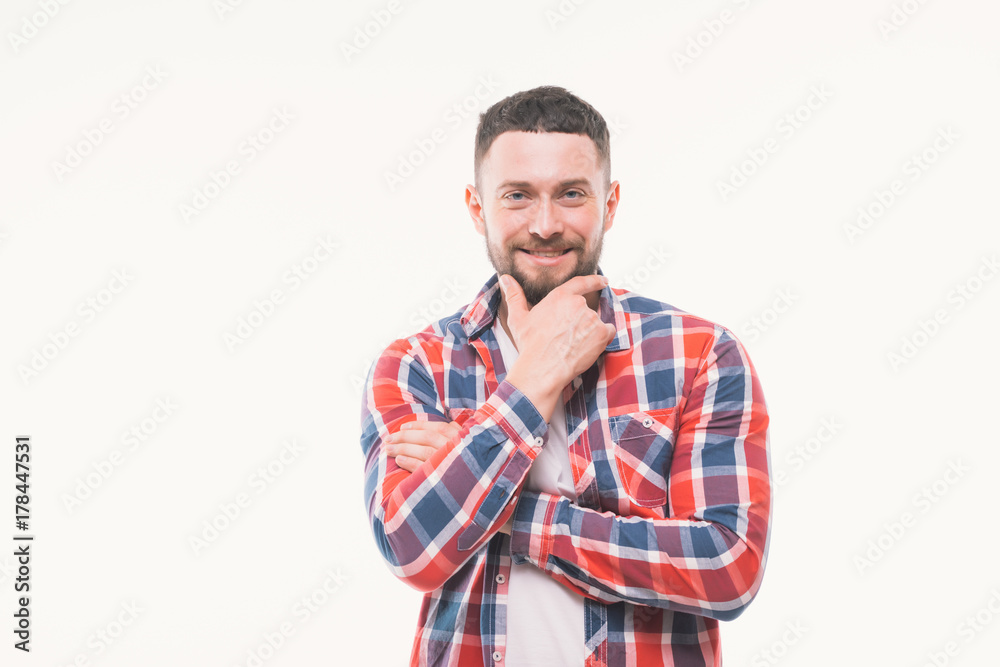 Handsome happy beard young man smiling and holding his chin, guy wearing red shirt, isolated on white background Handsome happy beard young man smiling and holding his chin, guy wearing red shirt, isolated on white background