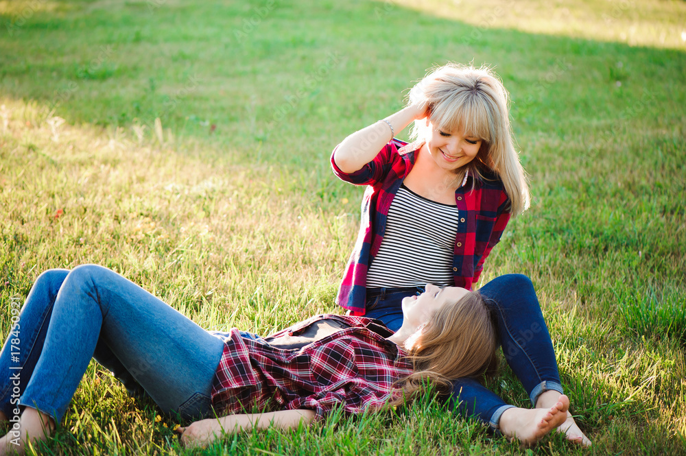 Two happy female friends playing and having fun in green grass Two happy female friends playing and having fun in green grass