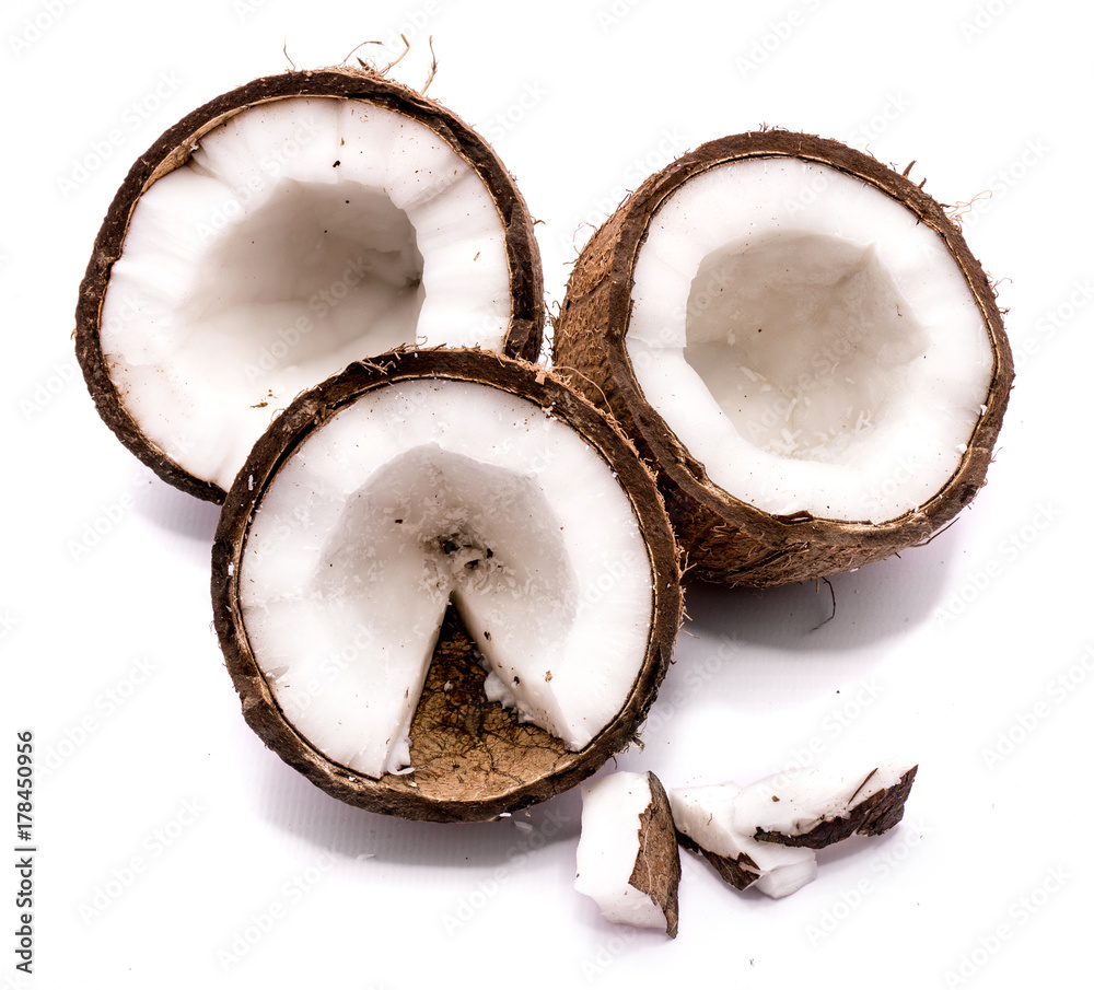 Three coconut halves and meat pieces isolated on white background Three coconut halves and meat pieces isolated on white background