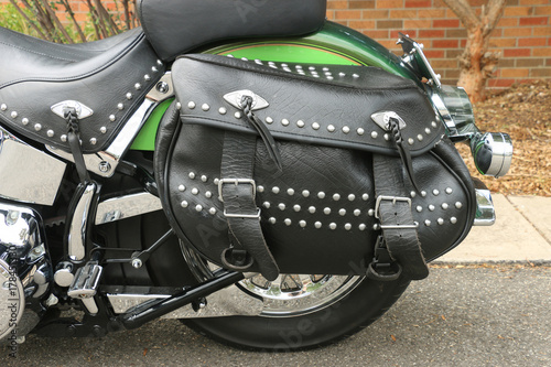 a black leather motorcycle saddlebag pannier with studs, fringes and buckles photo