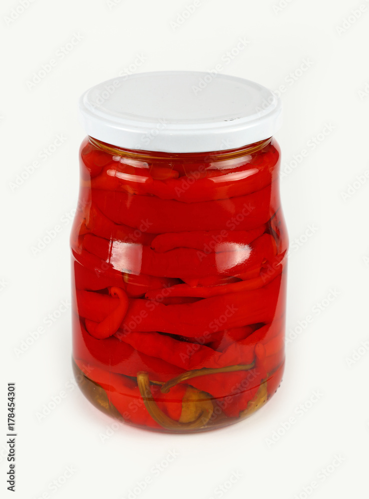 Jar of pickled red hot chili peppers over white Jar of pickled red hot chili peppers over white