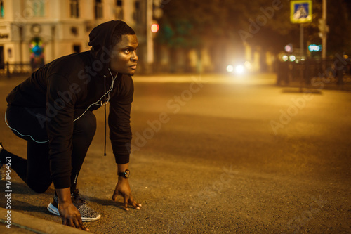 Athlete ready to start on city night photo