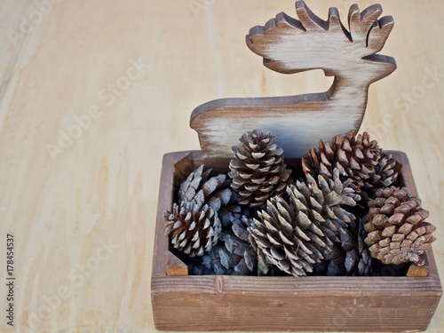 Fototapeta Naklejka Na Ścianę i Meble -  elk-shaped wooden container for pine cones on right position