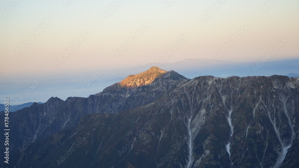 北アルプス槍ヶ岳登山、朝日を受けて光る笠ヶ岳を槍ヶ岳から見る