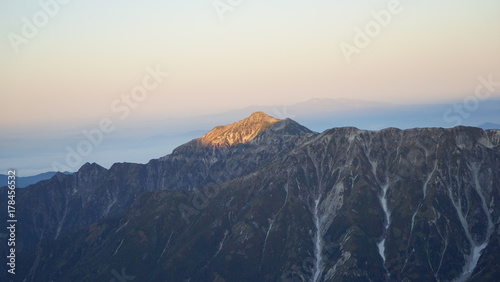 北アルプス槍ヶ岳登山、朝日を受けて光る笠ヶ岳を槍ヶ岳から見る