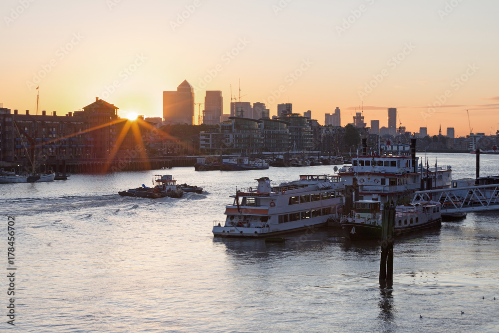 London - The ships in the pier and the Canary Wharf at the sunrise.