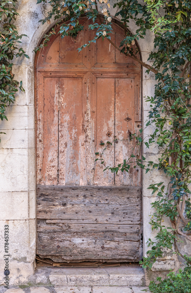 Fototapeta premium Old wooden door in the entrance stone French house