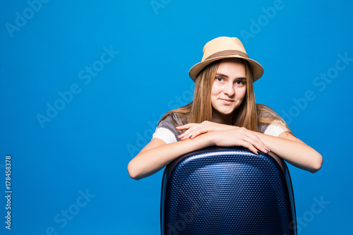 Pretty Woman with Travel Baggage on Blue Background in Studio. Vacation, Traveling Concept. photo