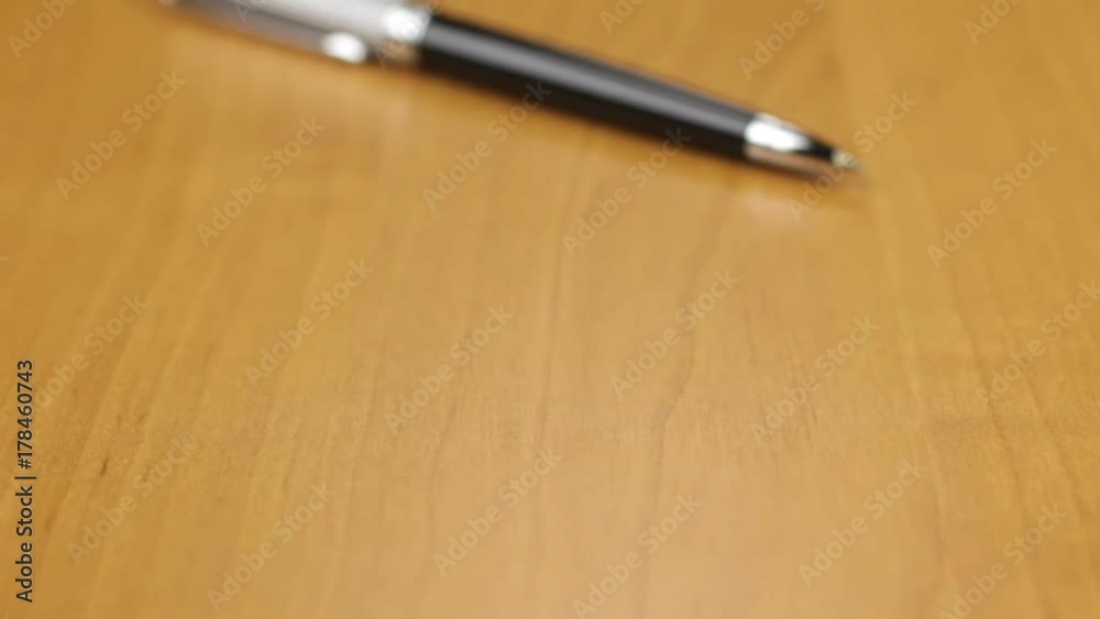 Dolly shot. Close-up silver ball pen lying on the table. Dolly shot. Close-up silver ball pen lying on the table.