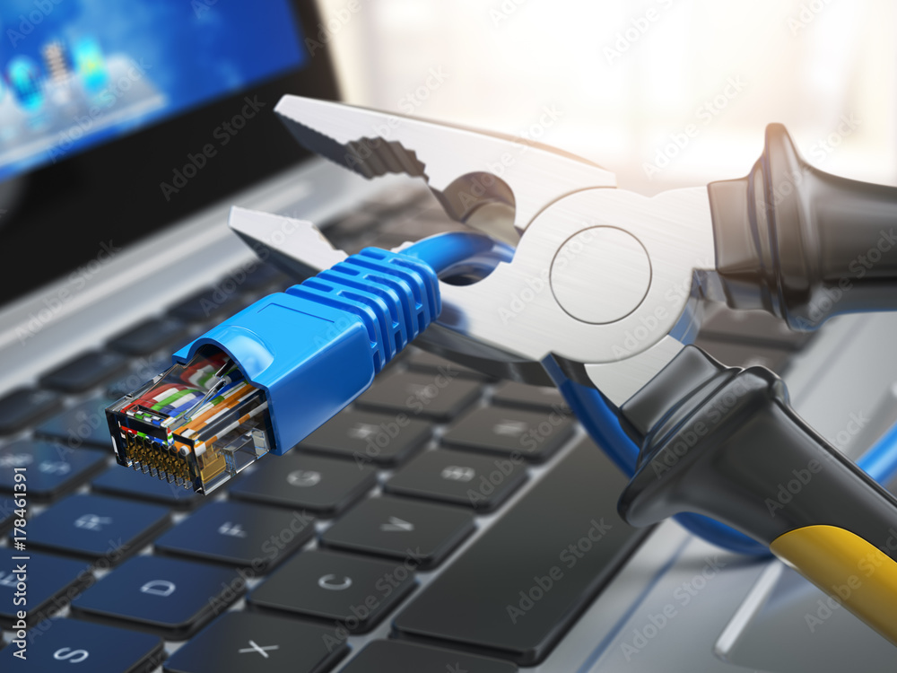 Pliers cutting lan network computer cable over laptop keyboard. Internet connection disconnected. Pliers cutting lan network computer cable over laptop keyboard. Internet connection disconnected.