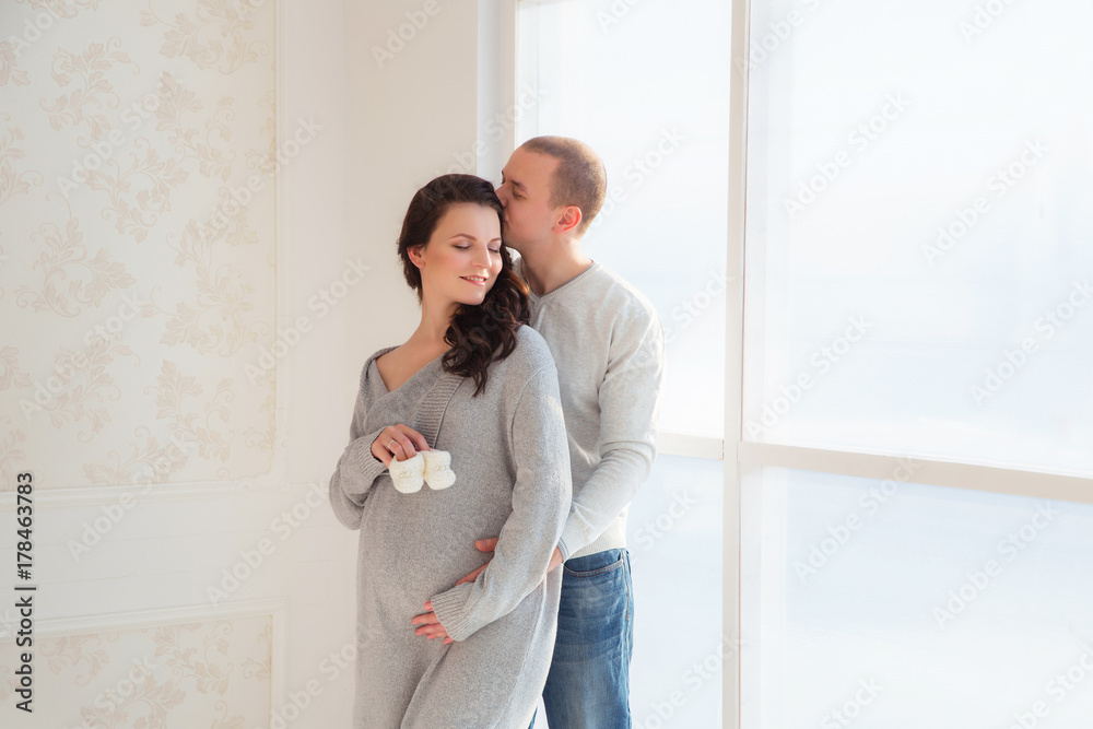 Pregnant woman and husband are smiling spending time together at home men touching tommy new apartment Pregnant woman and husband are smiling spending time together at home men touching tommy new apartment