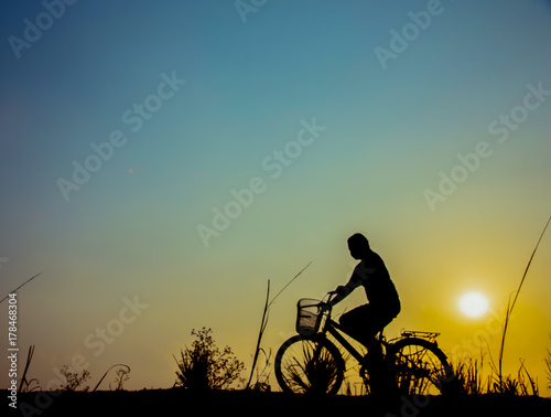 silhouette of a girl riding on a trail with his bike.