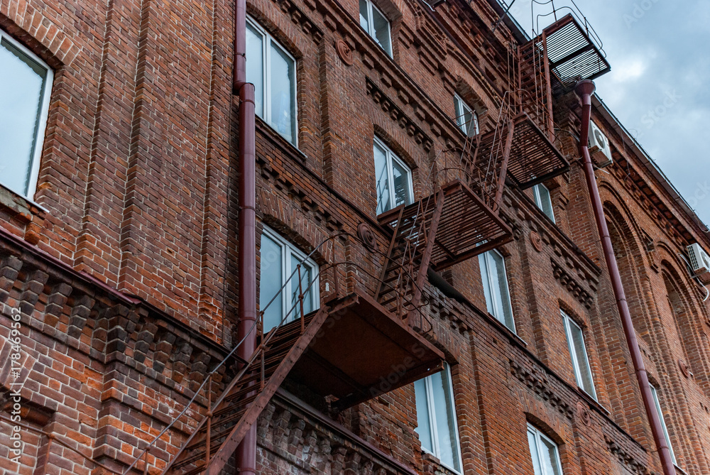 Metal ladder on old brick facade