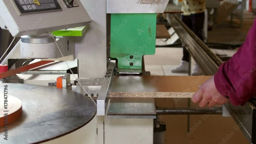 Automatic edge banding machine at a furniture factory Automatic edge banding machine at a furniture factory