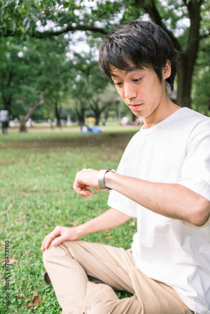 腕時計を見て驚く男性 腕時計を見て驚く男性