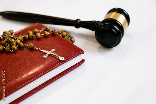 Photography judge's gavel and rosary beads on white background