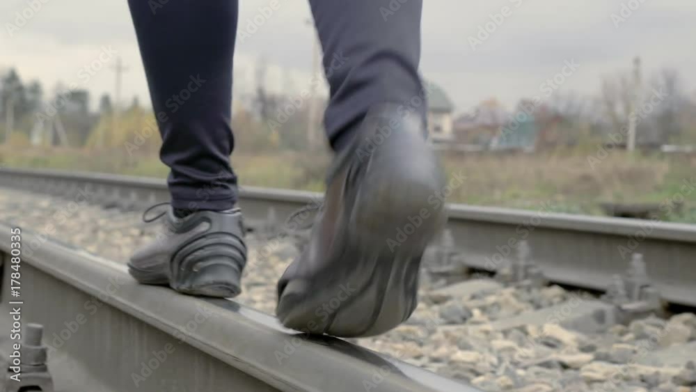 A woman walks by rail