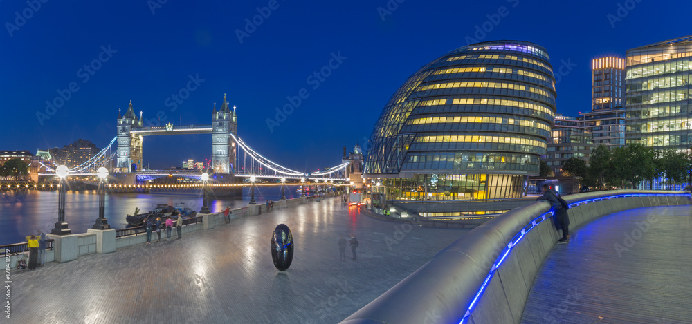 London - The panorama of the Tower bridge, promenade with the the modern Town Hall building at dusk.