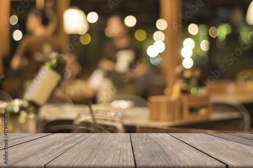 Mock up wooden table blank in front of blurred wine in restaurant background, used for presentation and product and text, warm circle bokeh