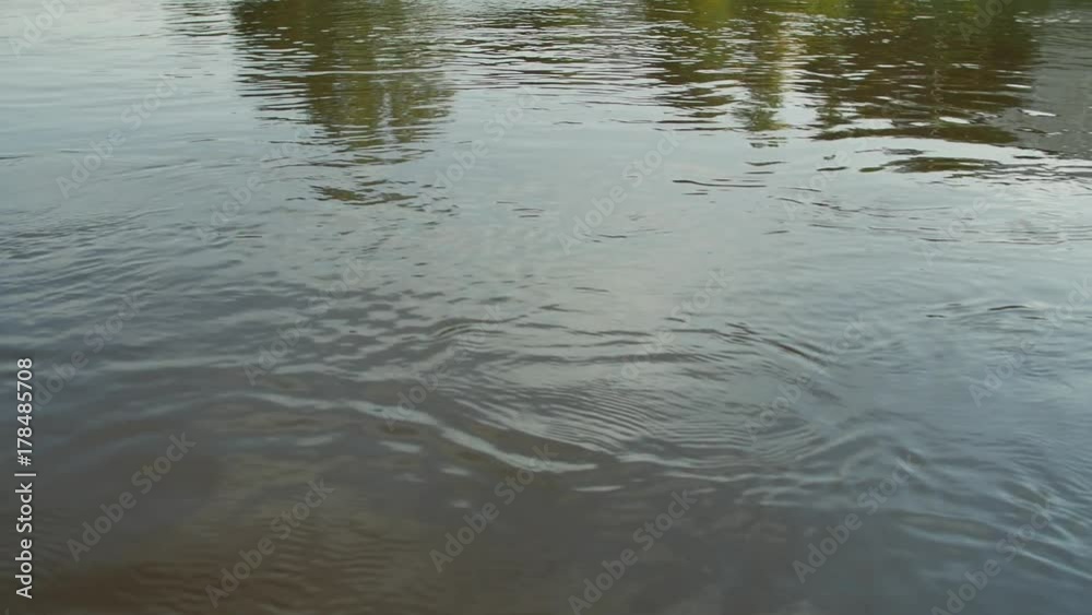 River water surface. Close-up of texture of nature works ripples on the water. Background meditative and hypnotic effect. River water surface. Close-up of texture of nature works ripples on the water. Background meditative and hypnotic effect.