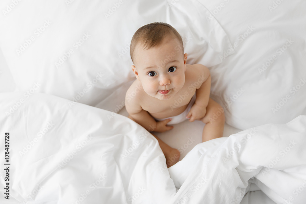 Cute sitting baby seen from above with tongue sticking out Cute sitting baby seen from above with tongue sticking out