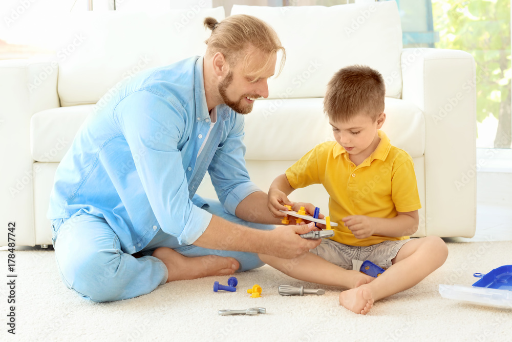 Father playing with cute son at home Father playing with cute son at home