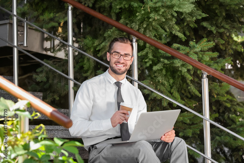 Handsome man with laptop an...