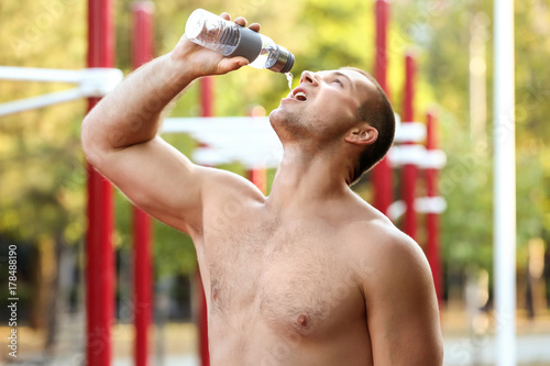 Sporty young man drinking w...