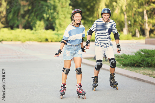 Young couple on roller skates in summer park