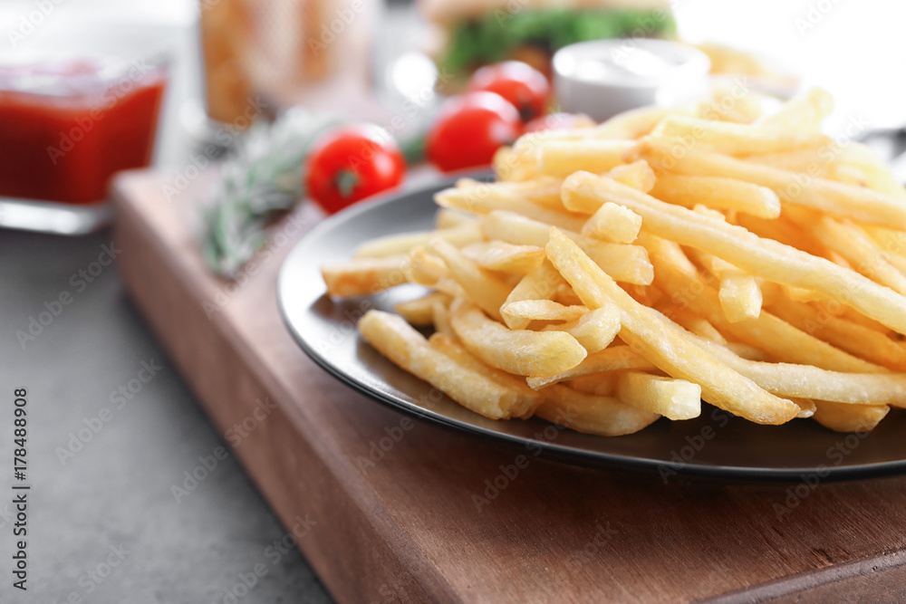Plate with yummy french fries on table, closeup Plate with yummy french fries on table, closeup