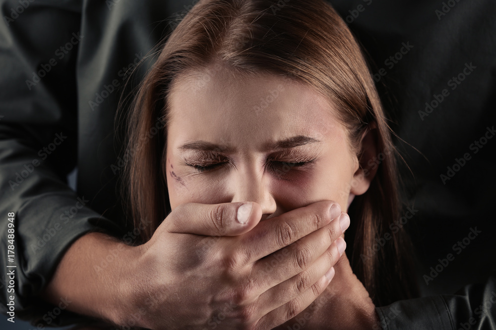 Man covering young woman's mouth Man covering young woman's mouth