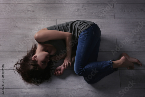 Battered young woman lying ...