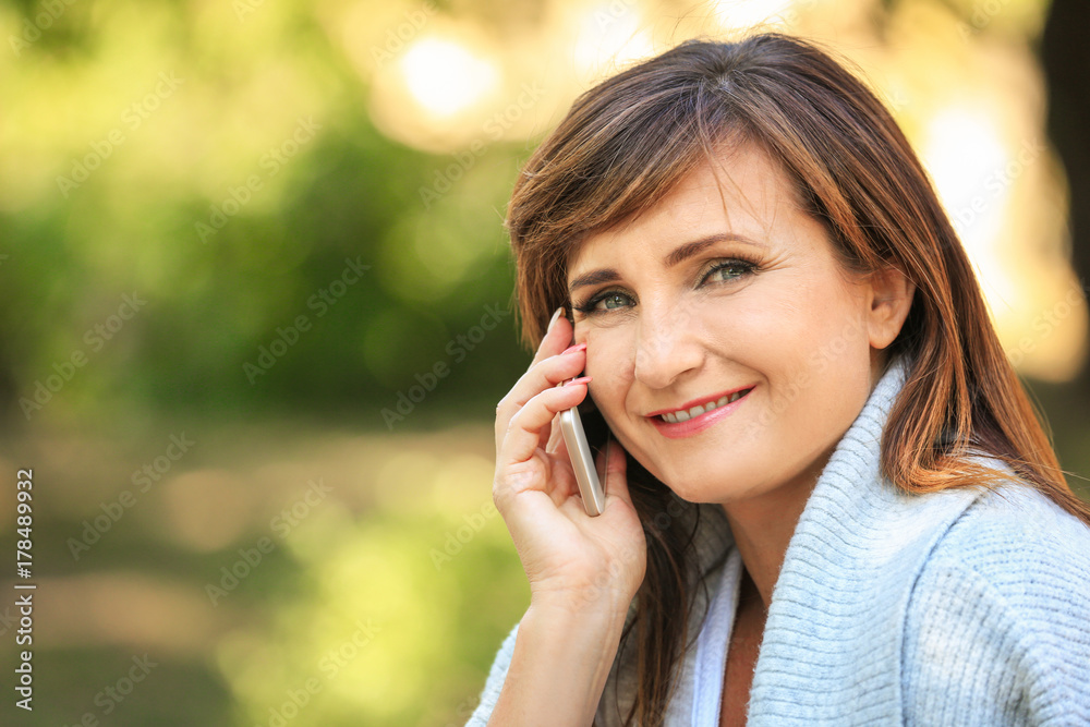 Mature woman talking on phone outdoors Mature woman talking on phone outdoors
