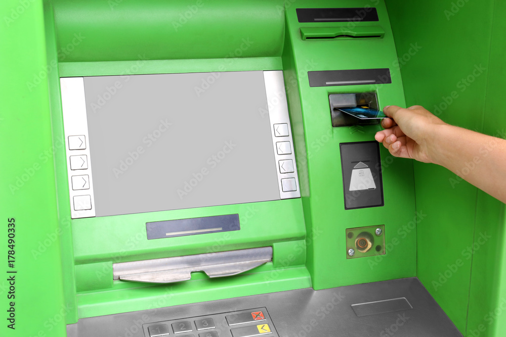 Woman inserting credit card into cash machine Woman inserting credit card into cash machine