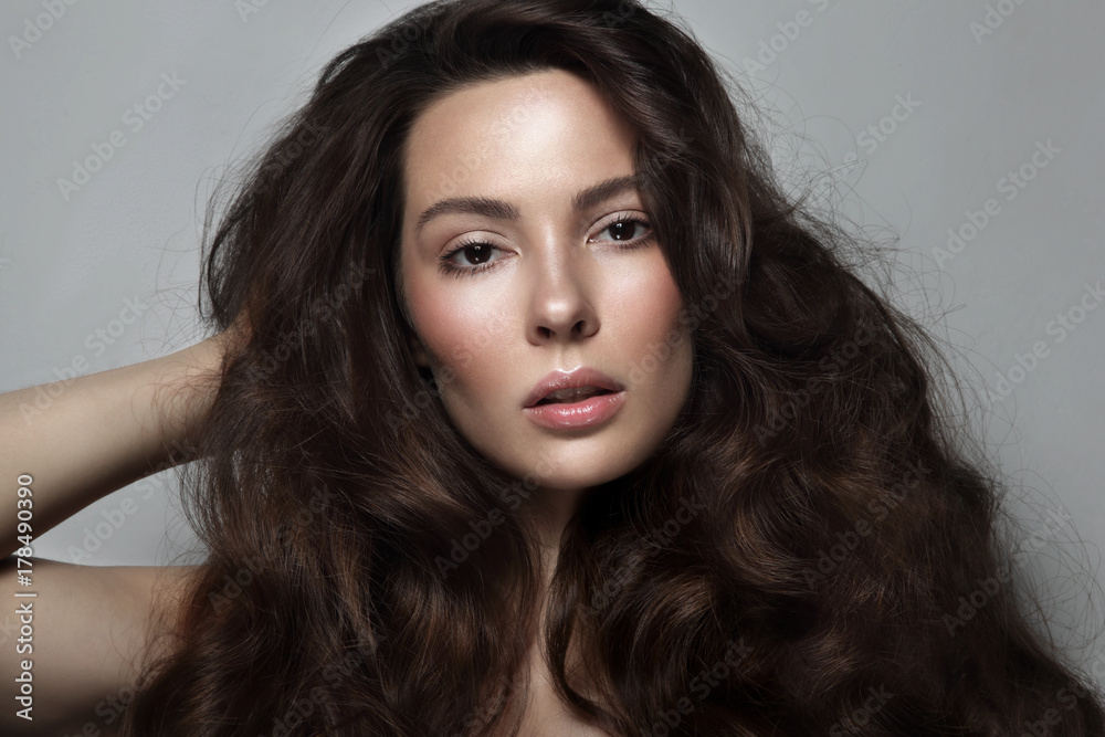 Young beautiful woman with long curly hair and clean make-up Young beautiful woman with long curly hair and clean make-up