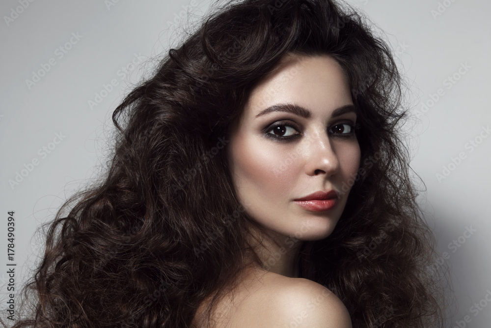 Vintage style portrait of young beautiful woman with long curly hair