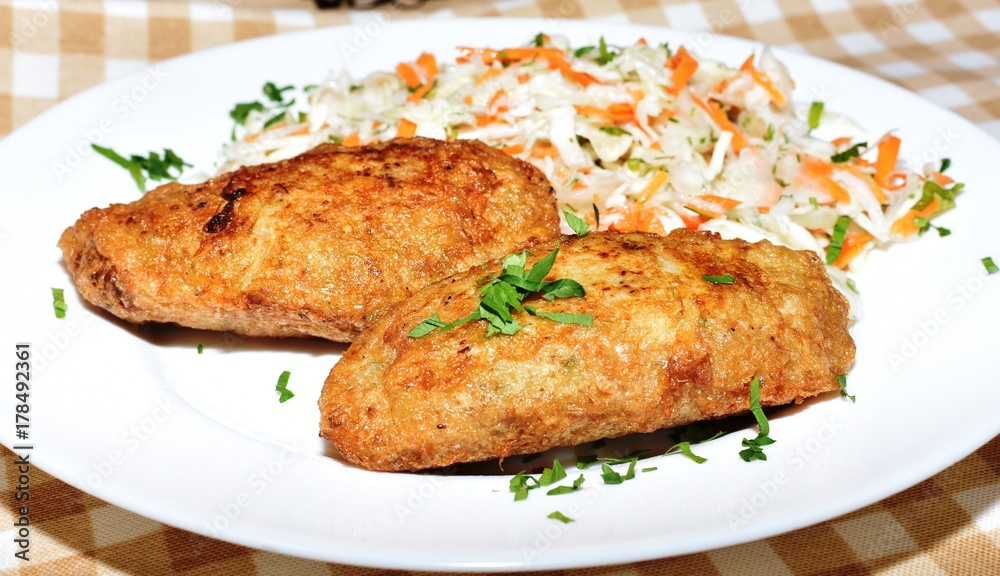 Two potato meatballs with a vegetable garnish Two potato meatballs with a vegetable garnish