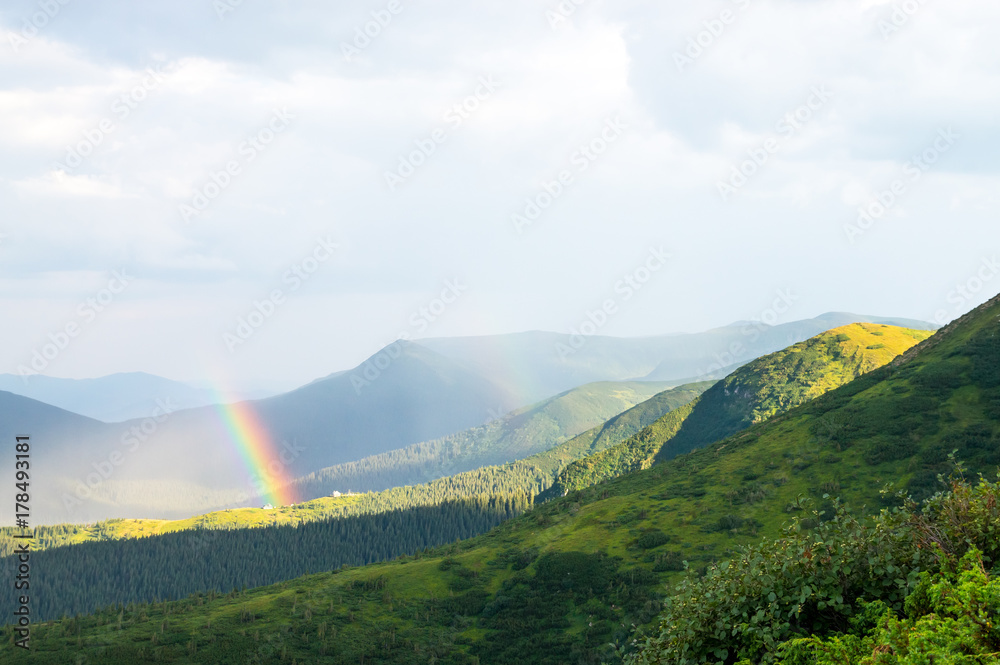 Rainbow and sunlight in the mountains over the houses